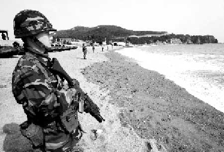 27日，韩国海军陆战队队员在沉船海域附近海滩巡逻。