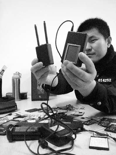 民警展示盗窃嫌犯使用的电子干扰器和解码器。记者 杜洪雷 摄