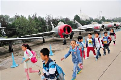 小学生在中国航空博物馆参观“少年先锋号”米格-15飞机。近日，该馆106架飞机被评为一级文物。本版图片/新京报记者 秦斌